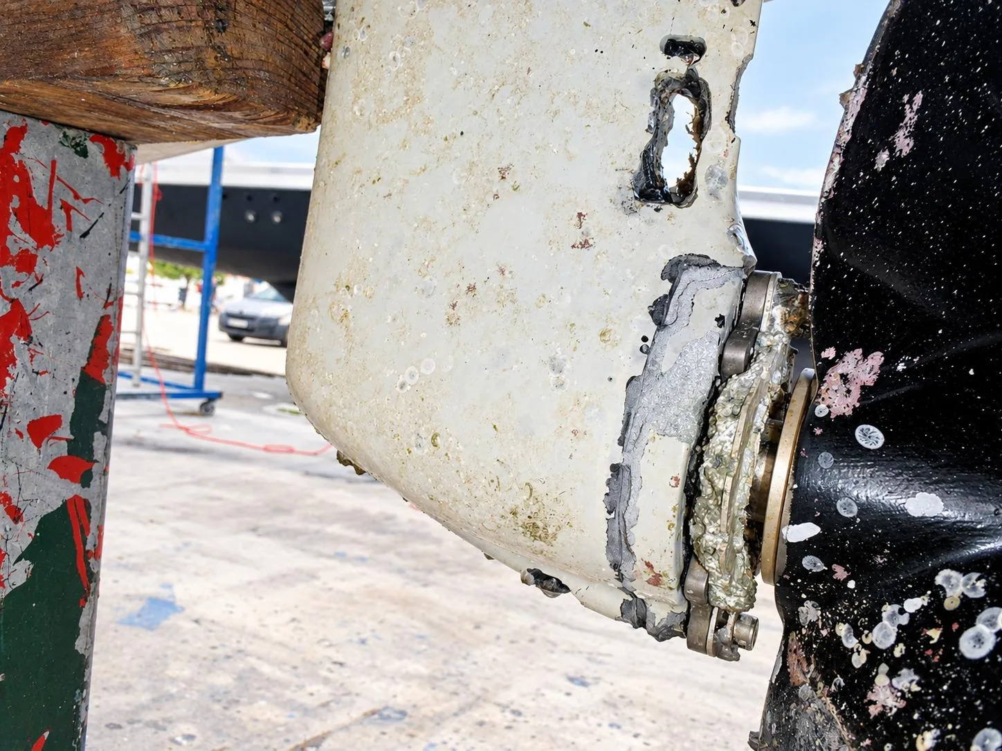 Corroded saildrive anode and trim tab inspected for galvanic corrosion on a yacht
