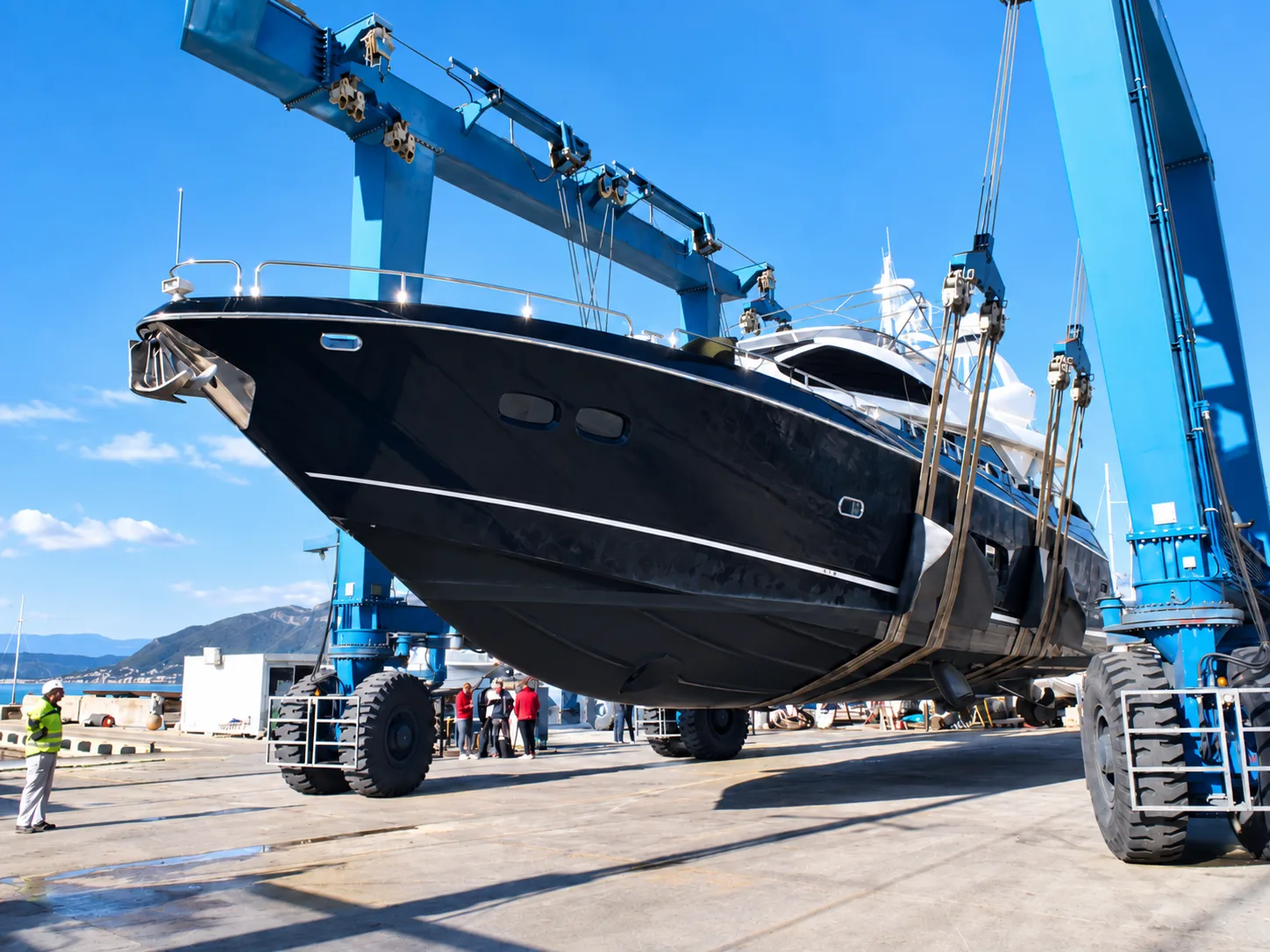 Motor yacht lifted by crane during hull inspection